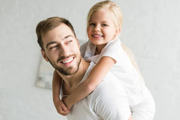 Щасливий батько і чарівна маленька дочка обіймається і розважається вдома — стокове фото