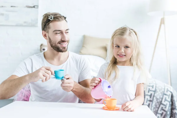 Счастливый отец и дочь играют вместе и притворяются, что у них чаепитие — стоковое фото