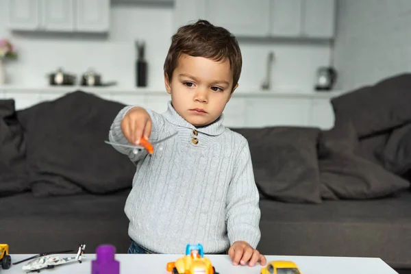 Bambino che gioca con l'aeroplano giocattolo in salotto a casa — Foto stock