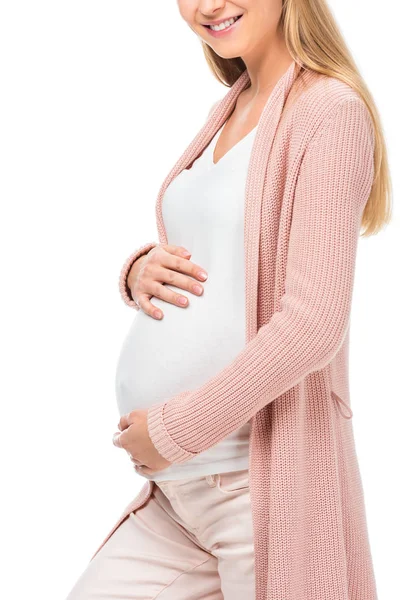 Vista cortada de mulher grávida em cardigan rosa tocando barriga isolada em branco — Fotografia de Stock