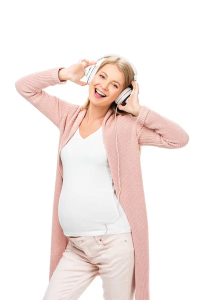 Щаслива вагітна жінка танцює з навушниками ізольовано на білому — стокове фото