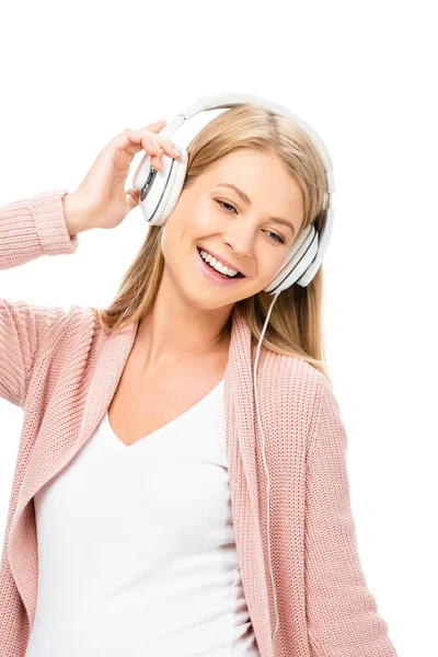 Donna incinta sorridente che tiene le cuffie e distoglie lo sguardo isolato sul bianco — Foto stock