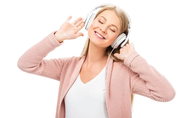Жінка насолоджується музикою, використовує навушники і посміхається із закритими очима ізольовано на білому — стокове фото