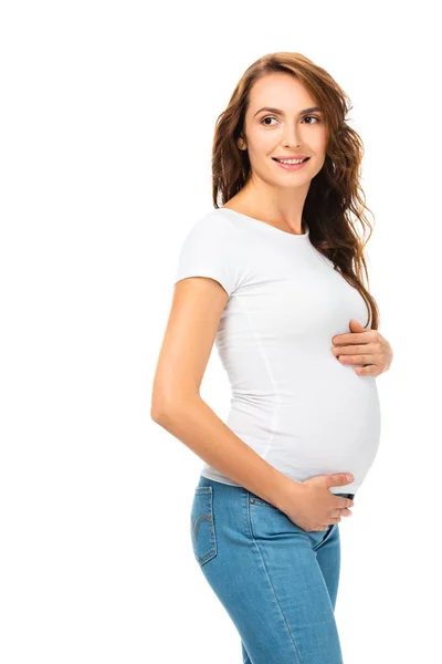 Красива вагітна жінка торкається живота і дивиться ізольовано на білому — стокове фото