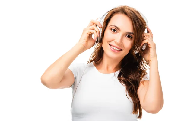 Hermosa mujer escuchando música, usando auriculares y mirando a la cámara aislada en blanco — Stock Photo