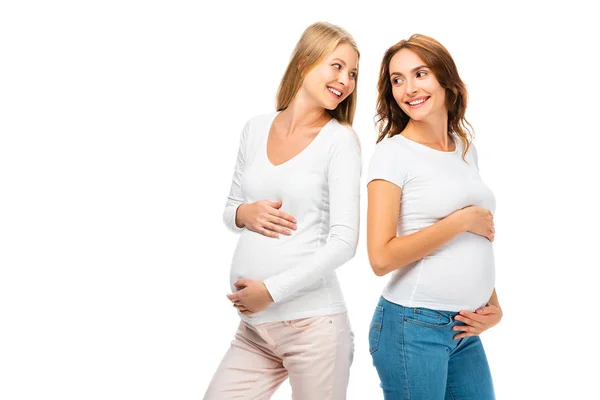 Schöne schwangere Frauen, die einander isoliert auf weiß betrachten — Stockfoto