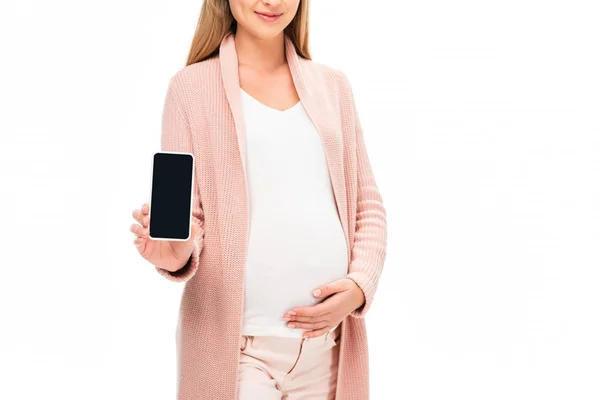 Hermosa mujer embarazada sosteniendo teléfono inteligente aislado en blanco - foto de stock