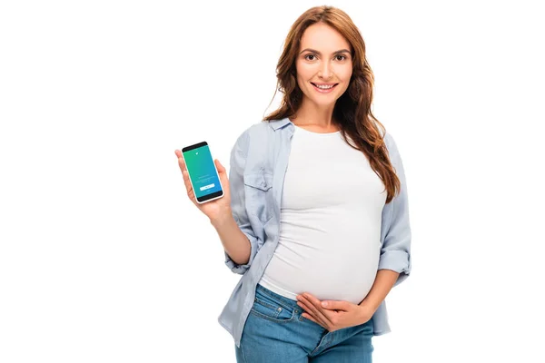 Belle femme enceinte tenant smartphone avec application twitter isolé sur blanc — Photo de stock