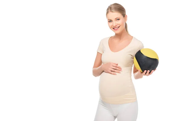 Щаслива вагітна блондинка тримає м'яч у лівій руці ізольовано на білому — стокове фото