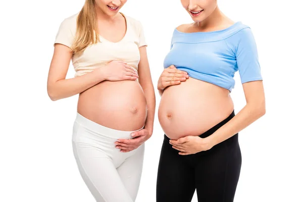 Cropped view of two pregnant women showing bellies isolated on white — Stock Photo