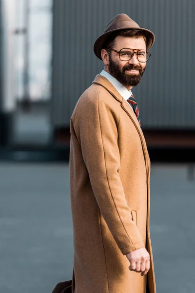 Hombre de negocios barbudo feliz en gafas de pie en el techo - foto de stock