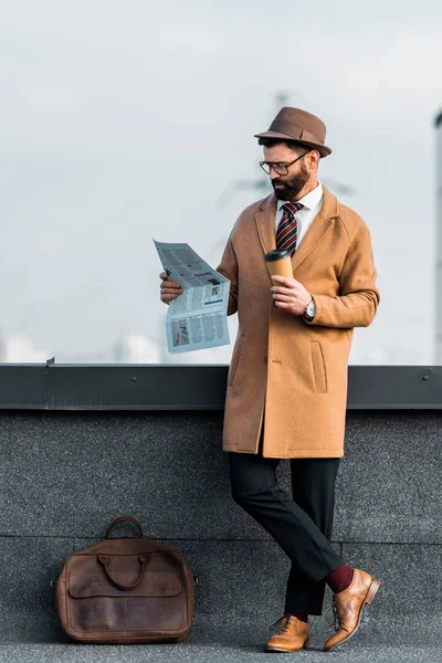 Uomo d'affari di successo con caffè per andare a leggere il giornale — Foto stock