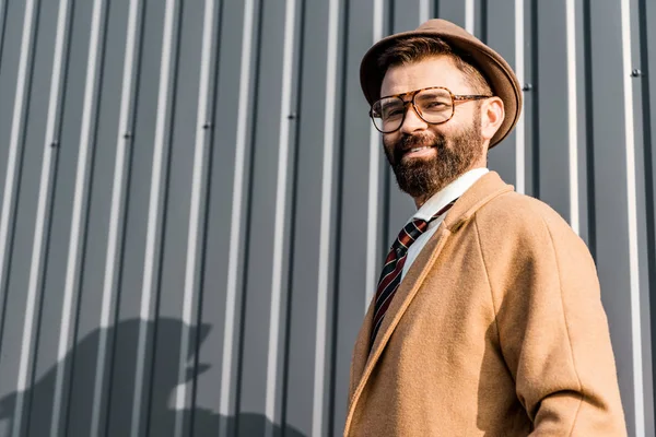 Cheerful bearded businessman smiling near textured wall — Stock Photo