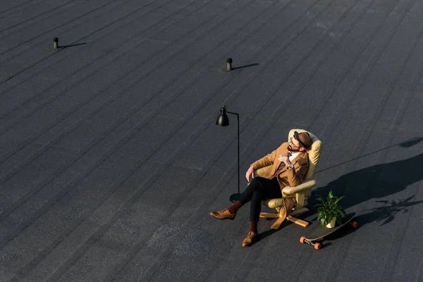 Adulto empresário descansando em poltrona com cigarro no telhado — Fotografia de Stock