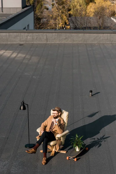 Uomo d'affari adulto rilassante in poltrona e fumare sul tetto — Foto stock