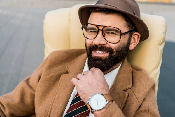 Close up of adult smiling businessman in hat and glasses looking at camera — Stock Photo