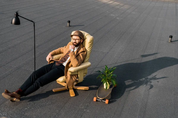 Bel homme d'affaires reposant dans un fauteuil sur le toit — Photo de stock