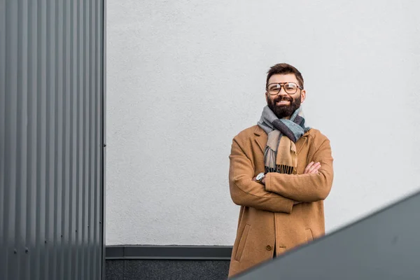 Homme d'affaires joyeux debout près du mur avec les bras croisés — Photo de stock