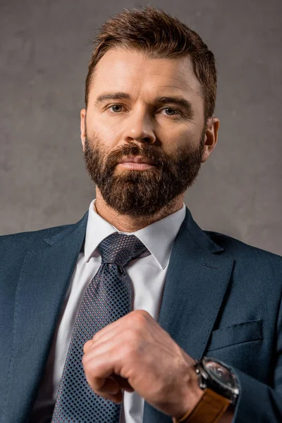 Close up of serious businessman in formalwear with watch on hand — Stock Photo