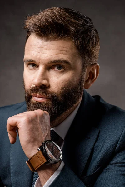 Close up of thoughtful bearded businessman with watch on hand — Stock Photo