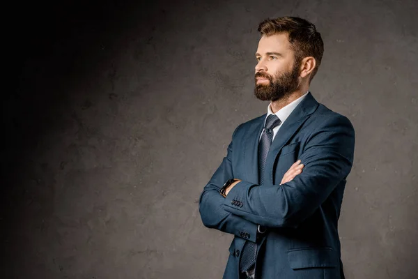 Exitoso hombre de negocios barbudo de pie con brazos cruzados - foto de stock