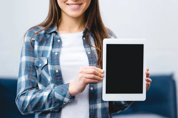 Обрізаний знімок усміхненої дівчини, що тримає цифровий планшет з порожнім екраном — стокове фото