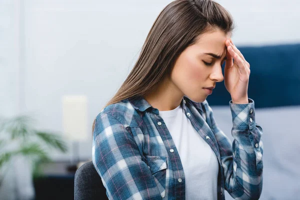 Jeune femme malade souffrant de maux de tête à la maison — Photo de stock