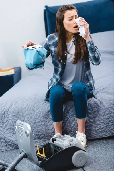 Mädchen mit Allergie-Auffangbehälter aus Staubsauger mit Staub und Niesen im Schlafzimmer — Stockfoto
