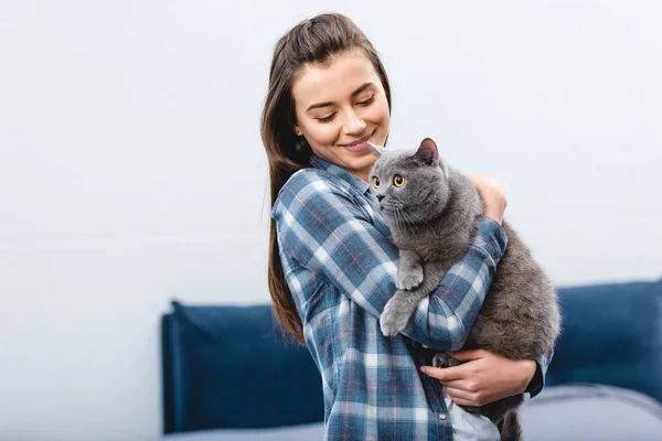 Sonriente joven mujer holding lindo británico taquigrafía gato - foto de stock