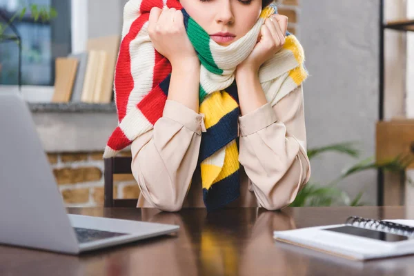 Обрізаний знімок хворої молодої бізнес-леді в шарфі, сидячи на робочому місці — стокове фото