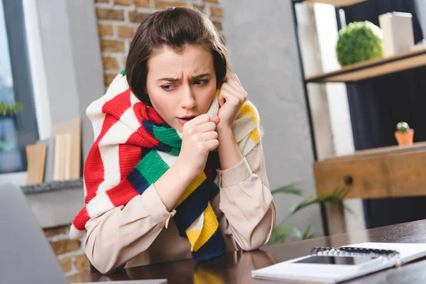 Хвора молода бізнес-леді в кашлі шарфів на робочому місці — стокове фото