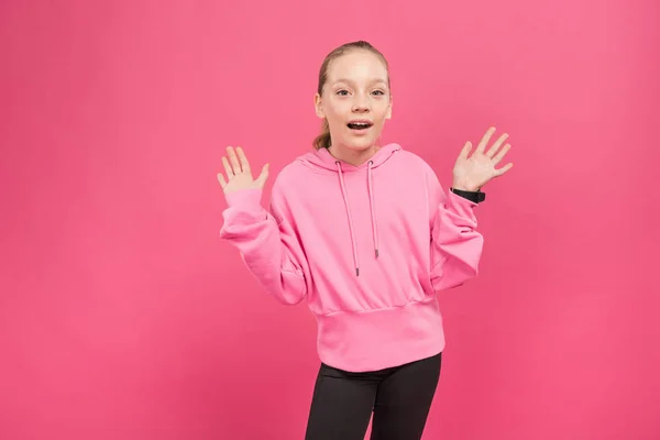 Aufgeregtes blondes Kind gestikuliert und blickt in die Kamera, isoliert auf rosa — Stockfoto