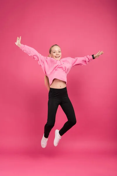 Happy blonde child jumping isolated on pink — Stock Photo