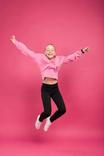 Adorabile allegro bambino saltando isolato su rosa — Foto stock