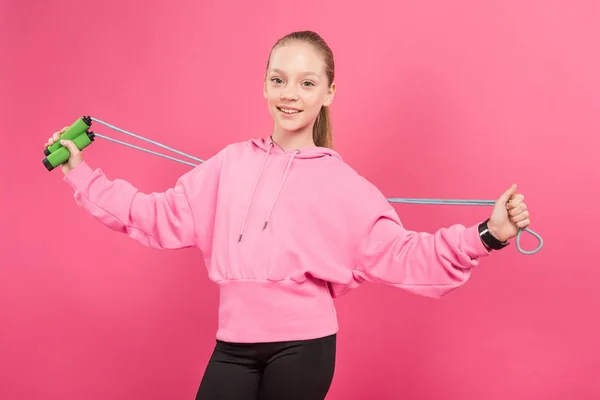 Glückliches Kind in Sportkleidung mit Springseil, isoliert auf rosa — Stockfoto
