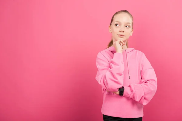 Entzückendes, nachdenkliches Kind in Sportkleidung isoliert auf rosa — Stockfoto