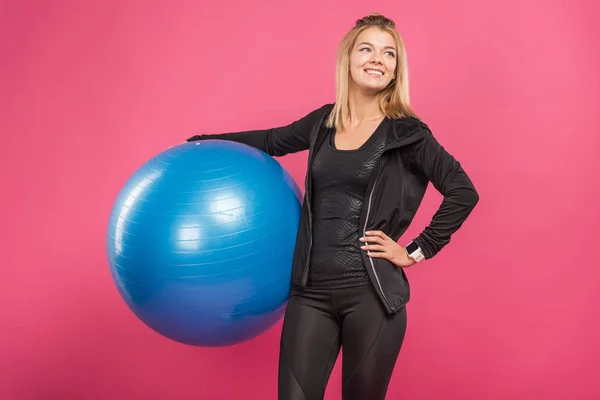 Schöne Sportlerin mit Fitnessbällen, isoliert auf rosa — Stockfoto