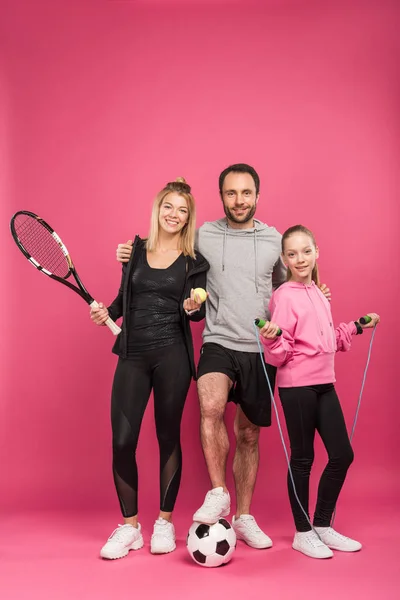 Sportliche Familie mit Sportausrüstung auf rosa — Stockfoto