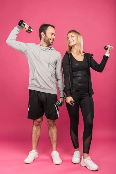 Treinamento casal esportivo feliz com halteres, isolado em rosa — Fotografia de Stock