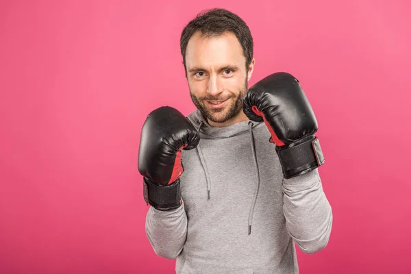 Красивый улыбающийся боксер, позирующий в боксёрских перчатках, изолированный на розовом — стоковое фото