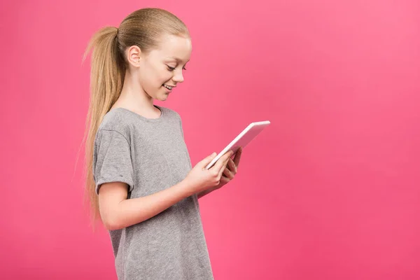 Adorable blonde kid using digital device, isolated on pink — Stock Photo