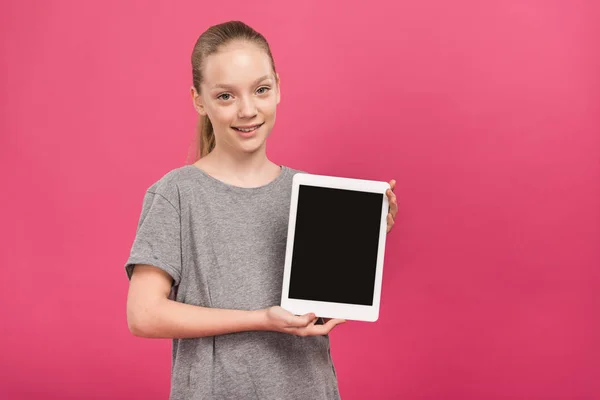 Criança adorável apresentando tablet digital com tela em branco, isolado em rosa — Fotografia de Stock