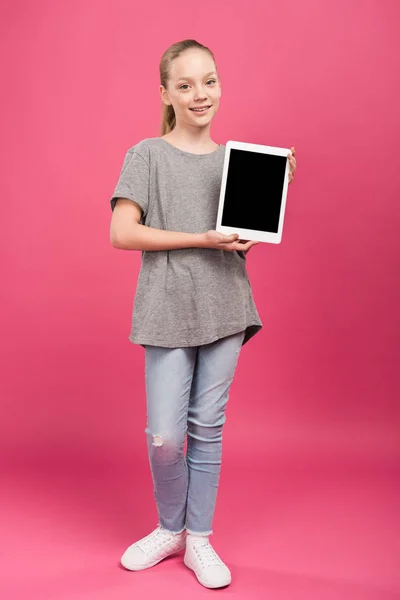 Enfant préadolescent présentant tablette numérique avec écran blanc, isolé sur rose — Photo de stock