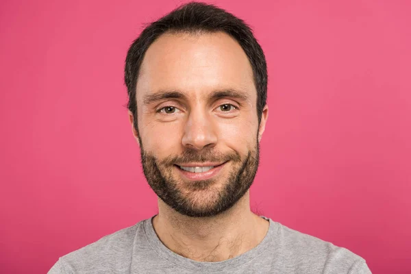 Porträt eines gut aussehenden lächelnden Mannes, der in die Kamera blickt, isoliert auf rosa — Stockfoto
