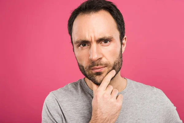 Portrait of pensive man looking at camera, isolated on pink — Stock Photo