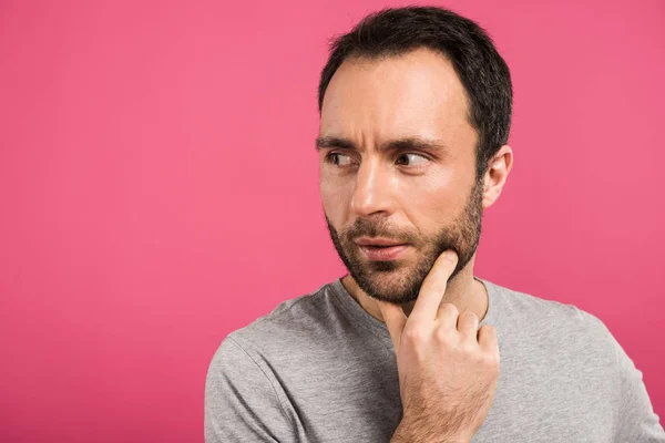 Porträt eines nachdenklichen Mannes, der wegschaut, isoliert auf rosa — Stockfoto