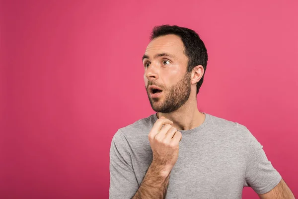 Porträt eines schockierten Mannes, der zur Seite schaut, isoliert auf rosa — Stockfoto