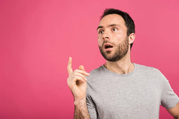 Portrait of handsome man having idea and pointing up, isolated on pink — Stock Photo