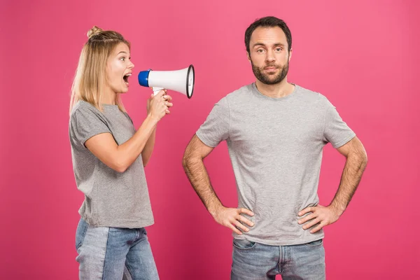 Petite amie en colère criant avec mégaphone au petit ami, isolé sur rose — Photo de stock