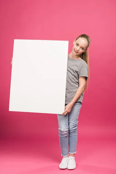 Rubia niña posando con tablero vacío, aislado en rosa - foto de stock